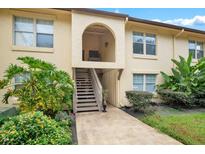 Condo exterior with plants, grassy areas, wooden steps and an arched entry way at 754 E Michigan St # 182, Orlando, FL 32806