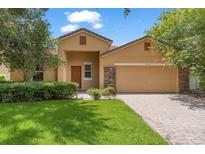 Charming single-story home with a well-manicured lawn, a two-car garage, and neutral-colored exterior paint at 9110 Stromboli Ct, Kissimmee, FL 34747