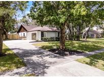 Charming single-story home featuring a spacious driveway and meticulously landscaped front yard with mature trees at 1121 Northern Way, Winter Springs, FL 32708