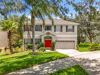 Two-story home boasts a landscaped front yard and bright red front door at 1602 Presidio Dr, Clermont, FL 34711