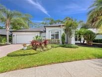 Beautiful single-story home with a well-manicured lawn and professional landscaping under a clear blue sky at 2342 Northumbria Dr, Sanford, FL 32771