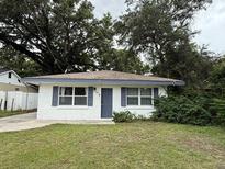 Charming single-story home features a crisp white exterior, blue shutters, and a well-maintained front yard at 341 Avenue L Ne, Winter Haven, FL 33881