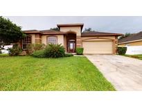 Well-maintained single-Gathering home featuring a manicured lawn and a two-car garage at 3552 Macauley Ct, Ocoee, FL 34761