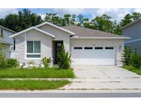 Contemporary one-story home featuring a two car garage, light stucco, stone accents, and well-maintained landscaping at 4028 Southern Vista Loop, St Cloud, FL 34772