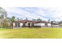 Charming single-story home with well-manicured lawn and lush landscaping creating great curb appeal at 18623 Tunbridge St, Orlando, FL 32833