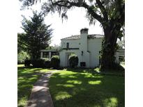 Two-story home with a tile roof, covered entrance, mature landscaping and a walkway through the front lawn at 2041 S Mellonville Ave, Sanford, FL 32771