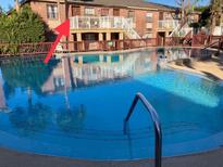 Community pool view of the apartments featuring well-maintained landscaping and blue water at 2525 Caper Ln # 205, Maitland, FL 32751