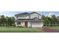 Inviting two-story home featuring a two-car garage, well-manicured lawn, and a mix of modern architectural details at 2577 Fiddle Leaf Loop, Apopka, FL 32712