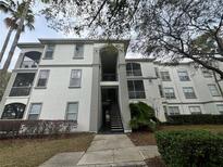 A charming condo building featuring well-maintained landscaping and inviting stairwell access at 2740 Maitland Crossing Way # 2-303, Orlando, FL 32810