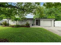 Charming single-story home featuring a manicured lawn, mature trees, and a welcoming front entrance at 654 Romano Ave, Orlando, FL 32807