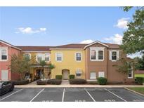 Attractive townhome featuring a colorful facade and well-manicured landscaping creating an inviting curb appeal at 962 Park Terrace Cir, Kissimmee, FL 34746