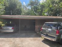 A single story home with a covered carport and two cars in the driveway at 1807 N Powers Dr, Orlando, FL 32818