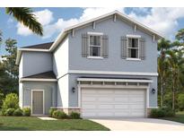 Charming two-story home features a light blue exterior, a two-car garage, and well-maintained landscaping at 3519 Salvia Ct, Tavares, FL 32778
