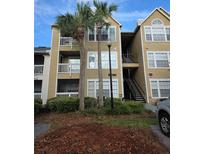 Multi-story condo building with mature palm trees and outdoor staircase to upper units at 1091 S Hiawassee Rd # 223, Orlando, FL 32835