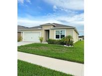Charming one-story home featuring a two-car garage and beautifully landscaped front yard at 577 Talisi Loop, St Cloud, FL 34771