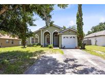 Charming single-story home with a well-manicured lawn and attached garage at 1558 Palmstone Dr, Apopka, FL 32703