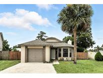 Charming single-Gathering home featuring a well-maintained lawn, a brick-accented garage, and a mature palm tree in the front yard at 7810 Wortham Ct, Orlando, FL 32825