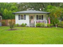 Charming home featuring a quaint porch, well-maintained lawn, and patriotic decorations at 805 E 20Th St, Sanford, FL 32771