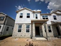 Under construction two-story exterior view showing the front entrance and the bare block and house wrap at 9368 Bolshoi Aly, Winter Garden, FL 34787