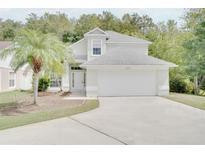 Two-story home featuring an attached two-car garage, neutral paint and meticulously maintained lawn at 2262 Stonehedge Loop, Kissimmee, FL 34743