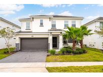 Charming two-story home featuring a two-car garage, lush landscaping, and a well-manicured lawn at 2613 Calistoga Ave, Kissimmee, FL 34741