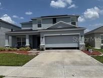 Charming two-story home with stone accents, well-manicured lawn, and spacious driveway at 564 Meadow Bend Dr, Davenport, FL 33837