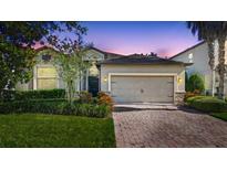 Charming home exterior with well-manicured lawn and beautiful brick driveway at dusk at 2008 Curia Rd, Winter Garden, FL 34787