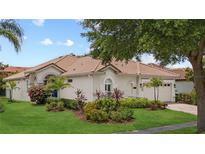 Charming single-story home showcasing lush landscaping, a light-colored exterior, and a beautiful, tiled roof at 11222 Rapallo Ln, Windermere, FL 34786
