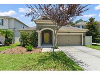 Charming home featuring a well-maintained lawn, a two-car garage, and a lovely yellow front door at 8065 Pleasant Pine Cir, Winter Park, FL 32792