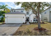 Charming two-story home boasts an attached two-car garage and a well-manicured front yard at 14217 Sapphire Bay Cir, Orlando, FL 32828