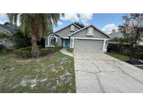 Charming single-Gathering home featuring a well-manicured lawn and a two-car garage at 324 River Chase Dr, Orlando, FL 32807