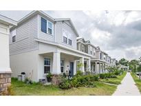 Charming two-story townhomes with attractive architectural details and inviting front porches on a sunny day at 4152 Pino St, Apopka, FL 32712