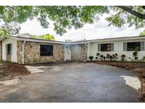 Charming single-story home with a stone facade and a spacious front driveway at 849 Forester Ave, Orlando, FL 32809