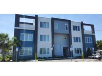 Modern building with blue and grey accents, featuring ample windows and handicap parking spaces at 7740 Sandy Ridge Dr # 102, Reunion, FL 34747