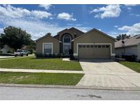 Charming single-Gathering home with a well-manicured lawn and attached two-car garage at 1639 Stanbury Dr, Orlando, FL 32818
