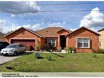Charming single-story home with well-maintained lawn and two-car garage at 675 Elbridge Dr, Kissimmee, FL 34758
