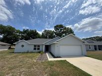 Charming single-story home featuring a two-car garage and well-maintained front yard at 7051 Sw 64Th Ter, Ocala, FL 34476