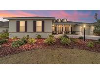 Beautiful single-story home with manicured landscaping, decorative shutters and covered front porch with sunset skies at 8160 Sw 92Nd Cir, Ocala, FL 34481