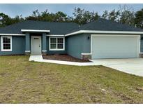 New single-story home with gray exterior, two-car garage, and landscaped lawn at 201 Locust Rd, Ocala, FL 34472