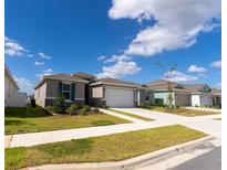 Charming one-story home with a well-manicured lawn and attached two-car garage under a sunny blue sky at 6396 Sw 72Nd Ter, Ocala, FL 34474
