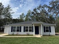 Charming single-story home with light siding, dark shutters, and a well-manicured lawn at 6 Fisher Way Pl, Ocklawaha, FL 32179