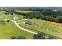 Aerial view of a home on a large lot with horse stables and riding arena at 11098 Nw 50Th Ln, Ocala, FL 34482