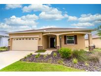 Charming single-story home with a two-car garage, landscaped front yard, and covered entryway at 9994 Sw 96Th St, Ocala, FL 34481