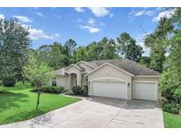 Single-story home with two-car garage and lush landscaping at 8257 Sw 196Th Court Rd, Dunnellon, FL 34432