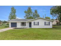 Newly renovated home with a freshly painted exterior and a well-maintained lawn at 5761 Ne 4Th Pl, Ocala, FL 34470