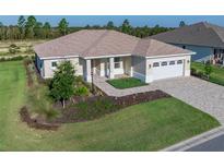 Charming single-story home featuring a well-manicured lawn, brick driveway and a two-car garage at 9400 Sw 106Th Ave, Ocala, FL 34481