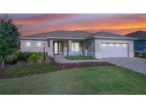 Inviting single-story home featuring manicured lawn, stone walkway, and a 2-car garage in a tranquil neighborhood at 9400 Sw 106Th Ave, Ocala, FL 34481