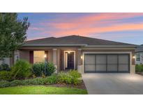 Charming single-story home featuring a well-manicured lawn and an attached two-car garage at 7709 Sw 86Th Ct, Ocala, FL 34481