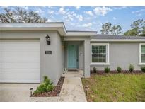 Charming single-story home with a well-maintained lawn and a bright, inviting turquoise front door at 7336 Sw 131St Ln, Ocala, FL 34473