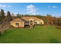 Single-story home with stucco exterior, landscaped lawn, and a two-car garage at 6925 Se 96Th Place Rd, Belleview, FL 34420